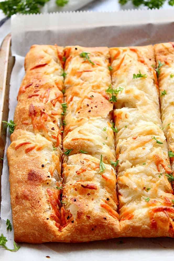 Close up shot of cheesy breadsticks in pan.