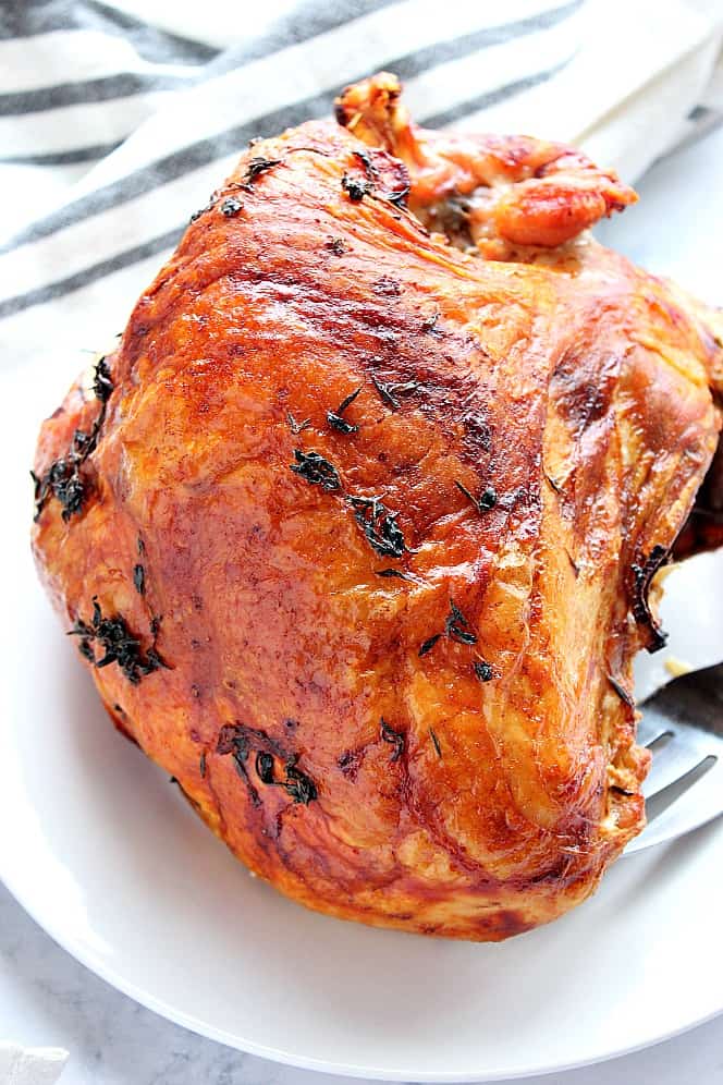 Overhead shot of turkey breast, roasted, placed on white serving dish.