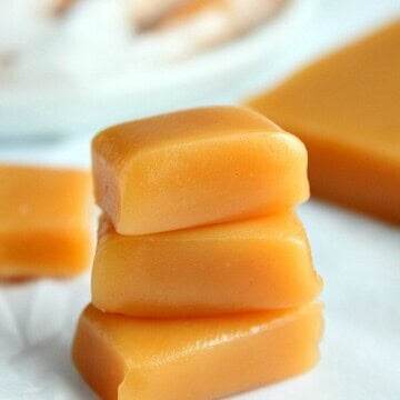 Microwave caramels stacked up on parchment paper.