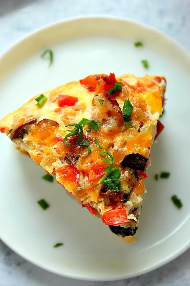 Overhead shot of a slice of egg casserole on white plate. 