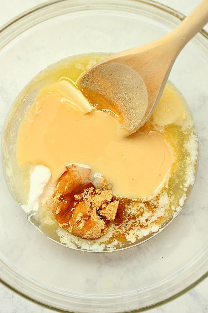 Overhead shot of glass bowl with melted butter, brown sugar and condensed milk. 