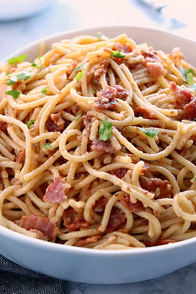 Side shot close up of pasta carbonara in white bowl. 