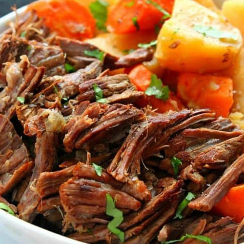 Pot roast with potatoes and carrots on plate.
