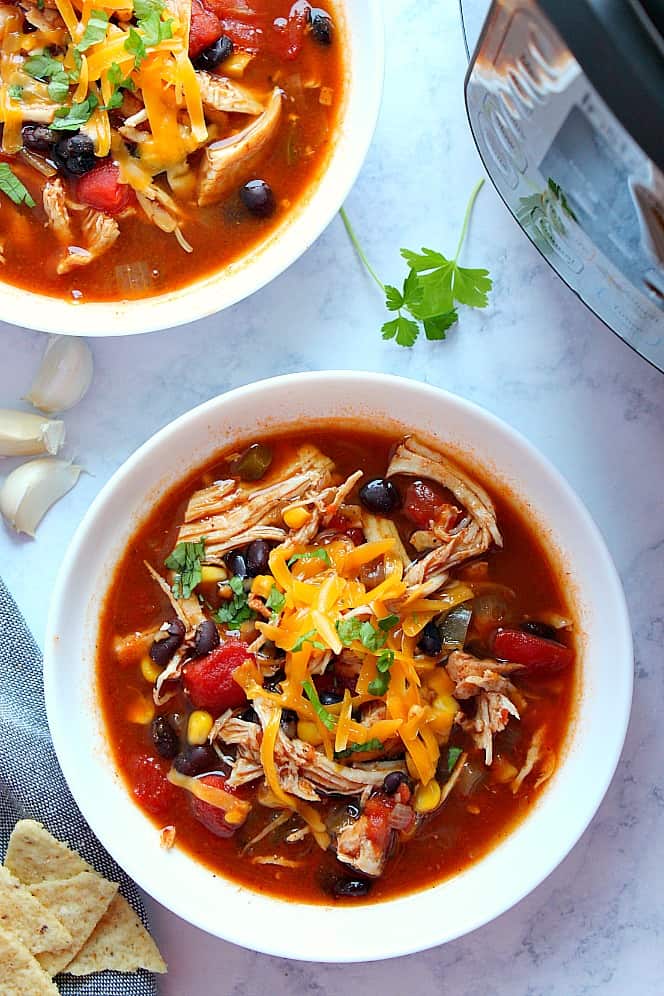 Overhead shot of two bowls of chicken tortilla soup next to Instant Pot.