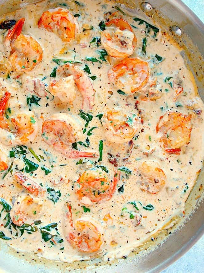 Overhead close up shot of creamy Tuscan shrimp in large pan.