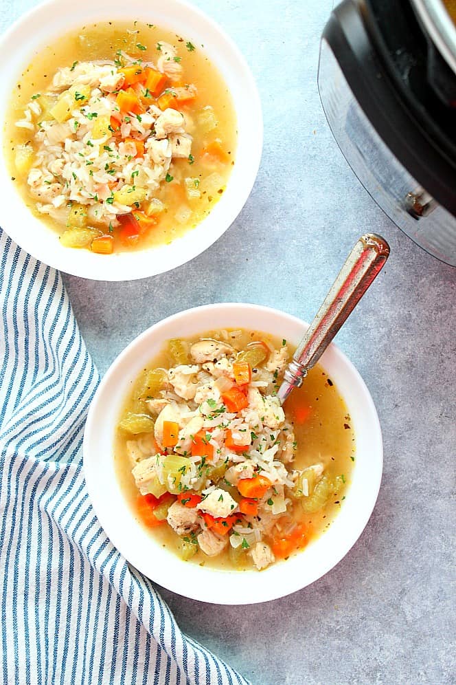 Overhead shot of two bowls with chicken and rice soup, next to the Instant Pot.