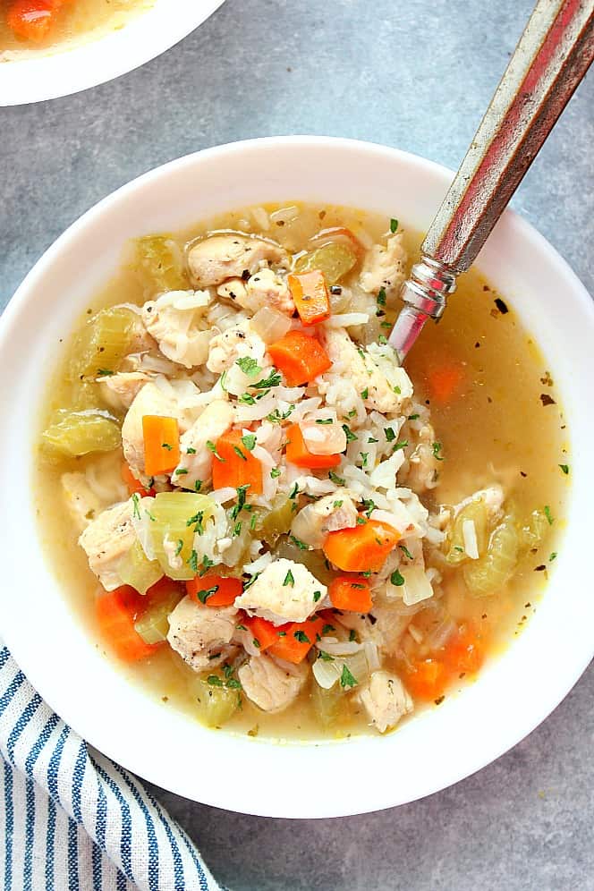 Overhead shot of chicken and rice soup in white bowl. 