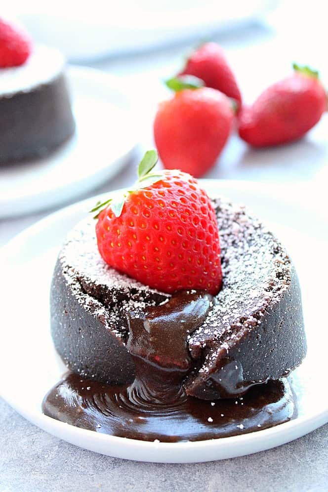 Side shot of chocolate lava cake with strawberry on top. 