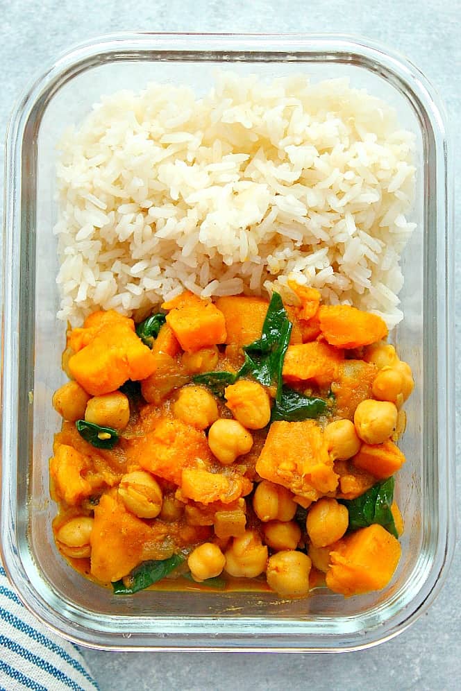 Overhead shot of rice and Instant Pot sweet potato curry in glass meal prep bowl.