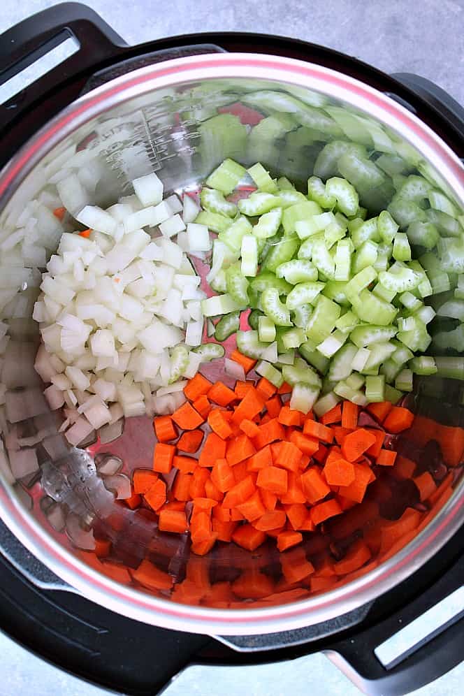 Overhead shot of chopped onions, carrots and celery in the Instant Pot.