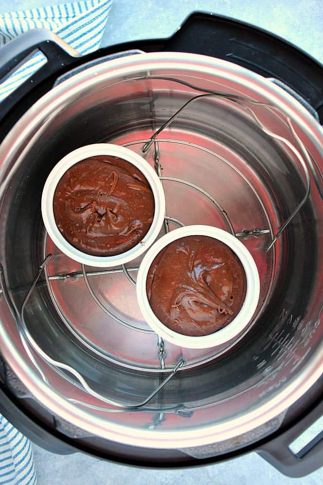 Overhead shot of two ramekins with chocolate cake batter, set on trivet in the Instant Pot.