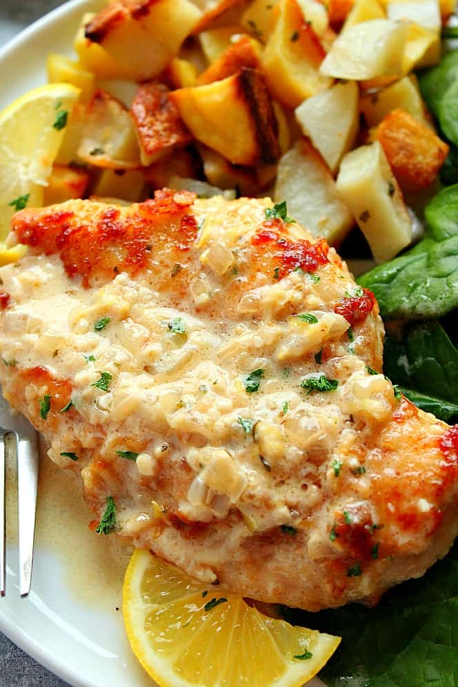 Lemon Garlic Chicken on a plate with potatoes and spinach.