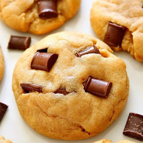 Peanut butter chocolate chunk cookies on a white sheet.