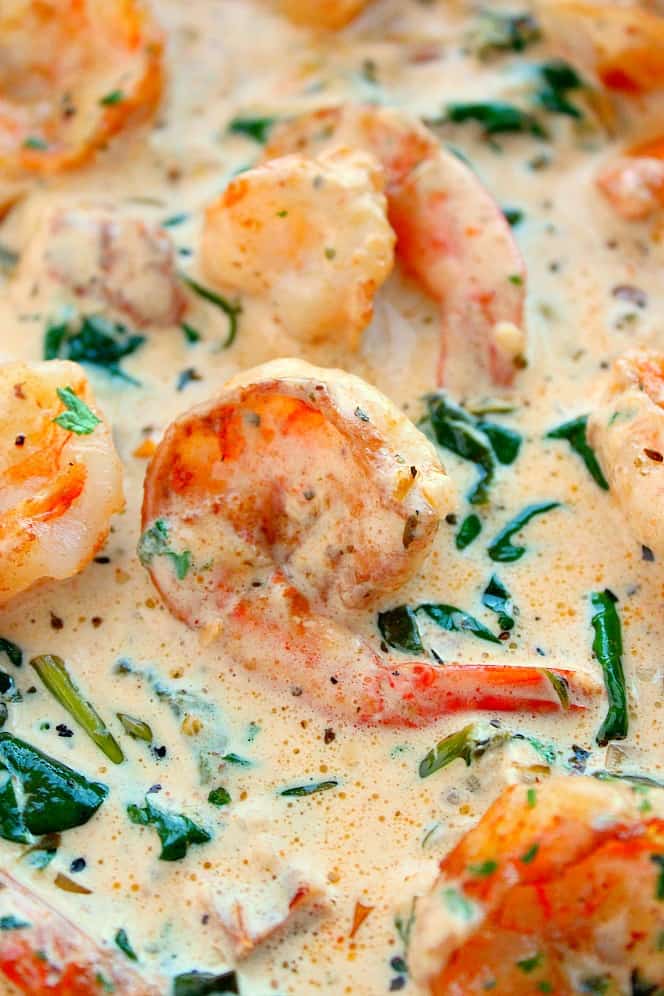 Close up shot of shrimp in creamy sauce with spinach. 