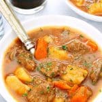 Instant Pot Beef Stew in a white bowl with spoon.
