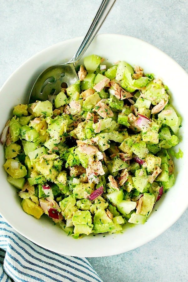 Avocado Tuna Salad Recipe - healthy and delicious salad made with ripe avocados, tuna, cucumber, celery and red onion. Perfect for sandwiches, wraps or eaten straight up! Avocado Tuna Salad in a large white bowl.