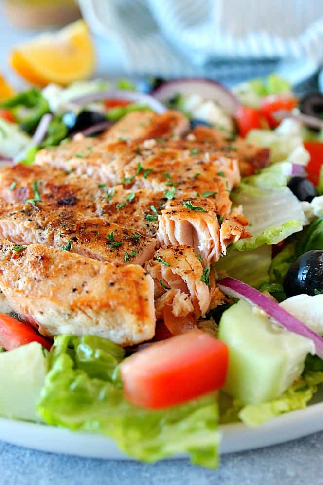 close up shot of salmon with Greek salad Greek Salmon Salad