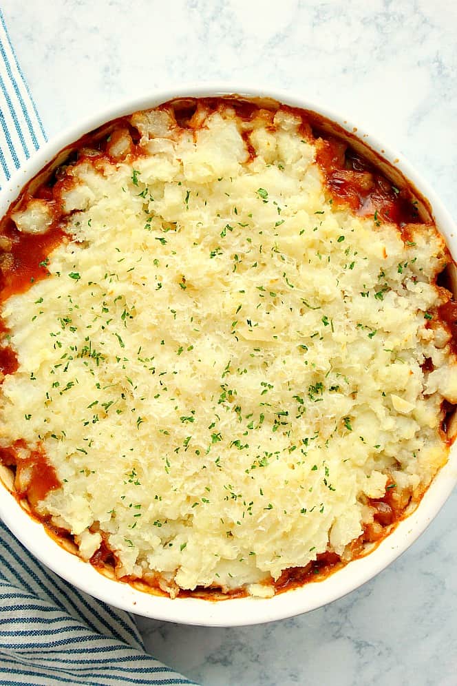 Overhead shot of vegetarian Shepherd's pie topped with mashed potatoes and baked in round dish.