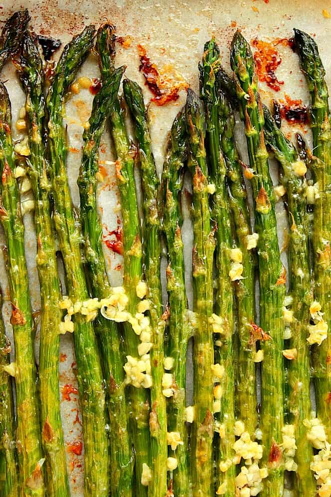 Overhead shot of roasted asparagus on parchment paper.