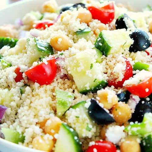 Close up shot of couscous salad in white bowl.