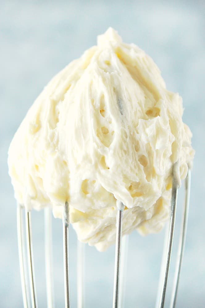 Close up shot of white frosting on a whisk.