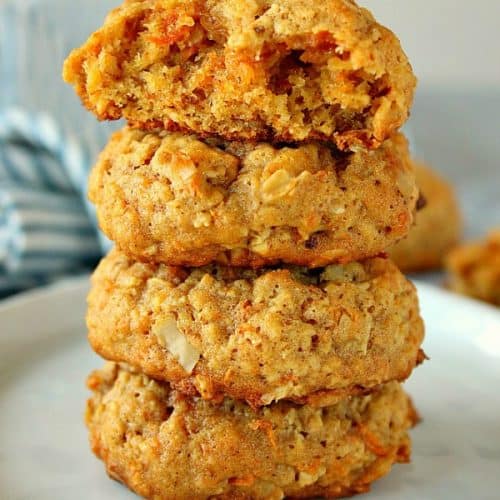 Carrot oatmeal cookies stacked on each other on white plate.