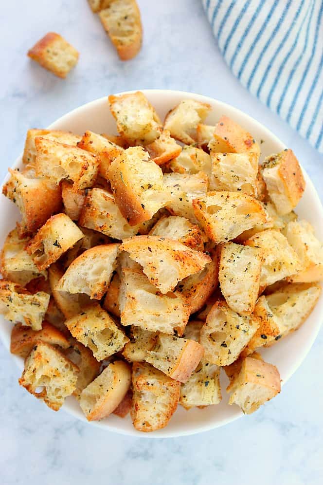 Overhead shot of homemade croutons in white bowl.