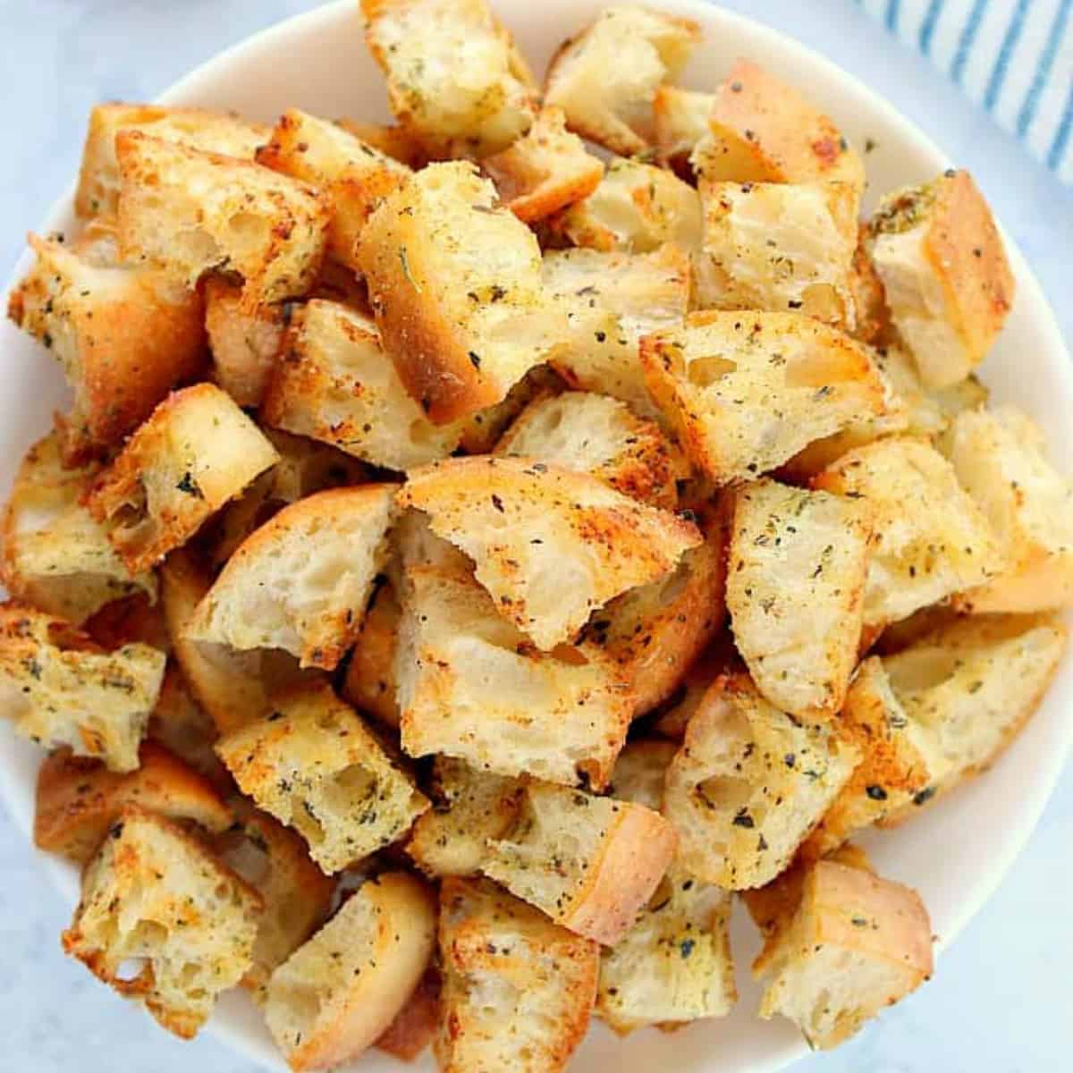 Homemade croutons in a white bowl.