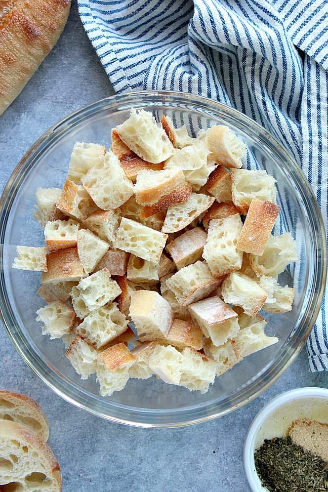 Overhead shot of cubed baguette in glass bowl.