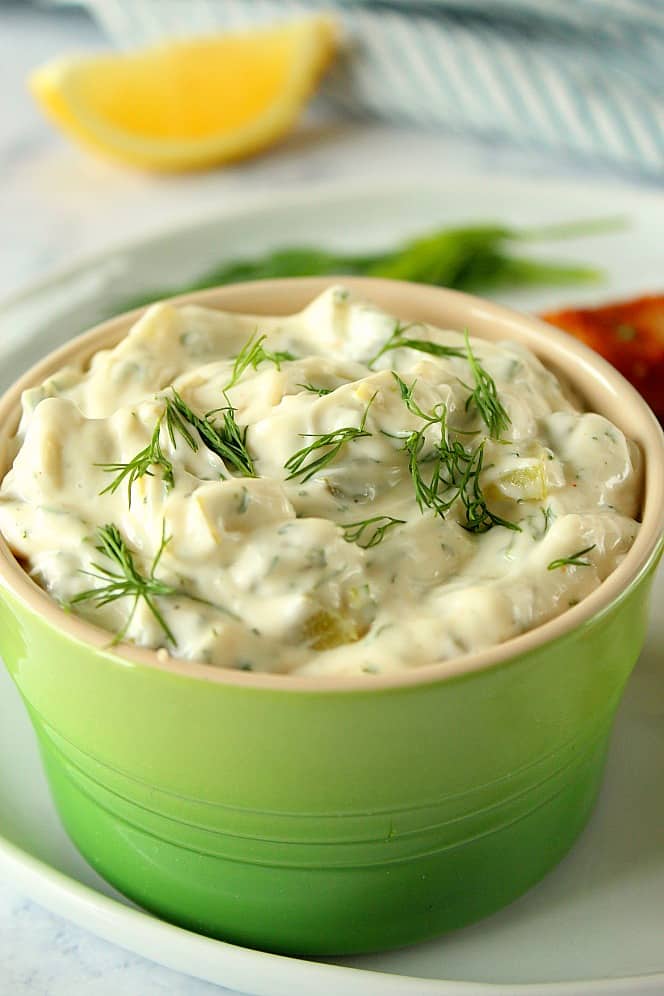 Tartar Sauce from Scratch is perfect for fish sticks, fish fillets and other seafood dishes. It's creamy, delicious and so much better than the store-bought kind! Side close up shot of homemade tartar sauce in green bowl.