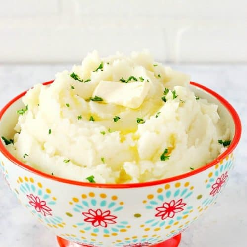 Instant Pot mashed potatoes in a bowl with red rim.