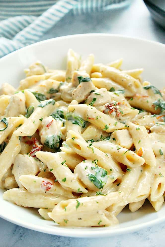 Close up shot of Instant Pot Tuscan chicken pasta in white pasta bowl.