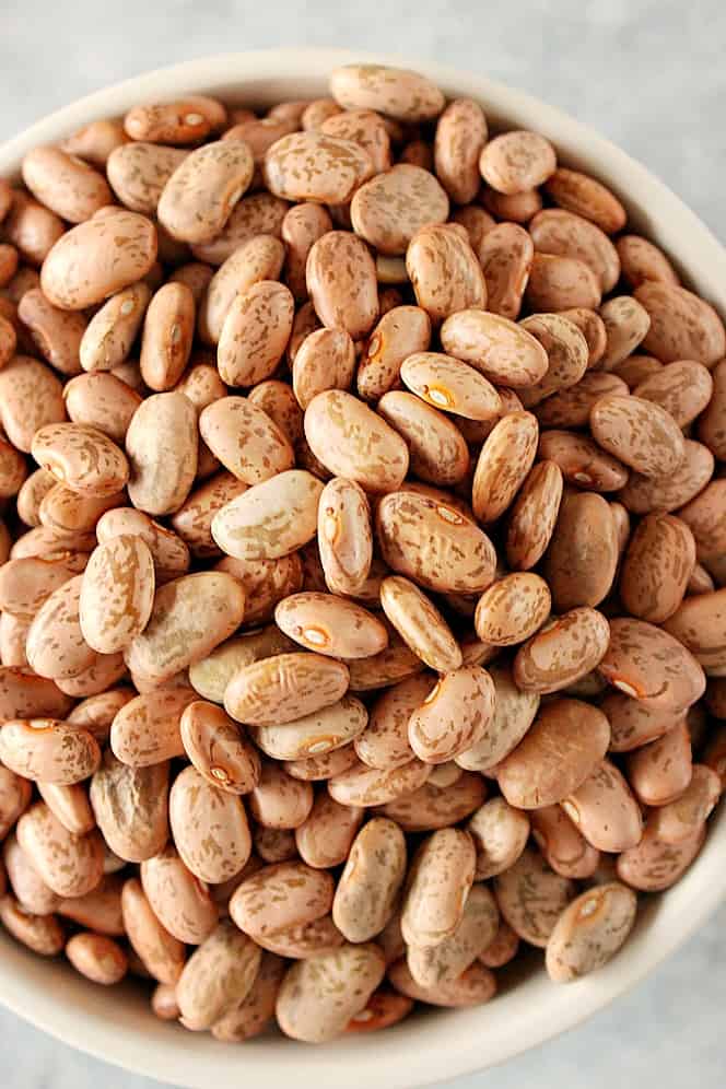 Close up shot of dry pinto beans in a bowl.