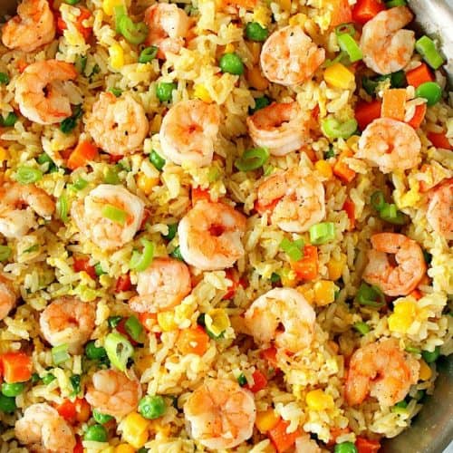 Fried rice with shrimp in a stainless steel skillet.