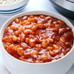 Baked beans in white bowl, next to Instant Pot.