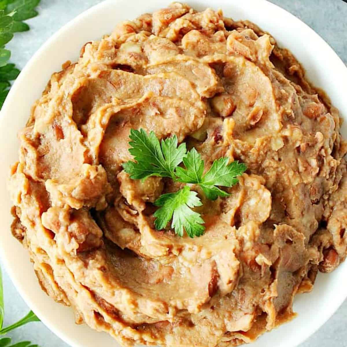 Refried beans in a white bowl.