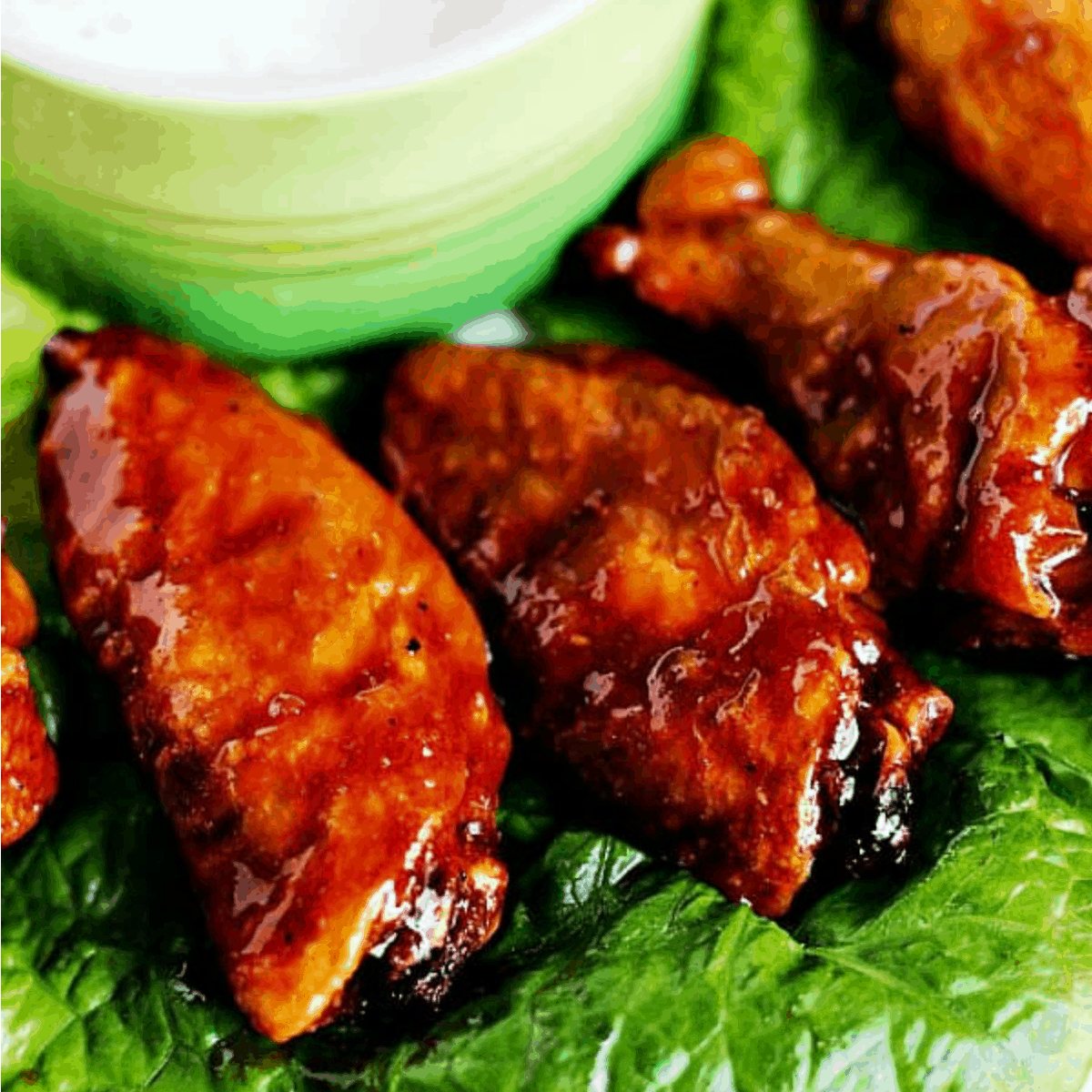 Chicken wings on a lettuce bed.