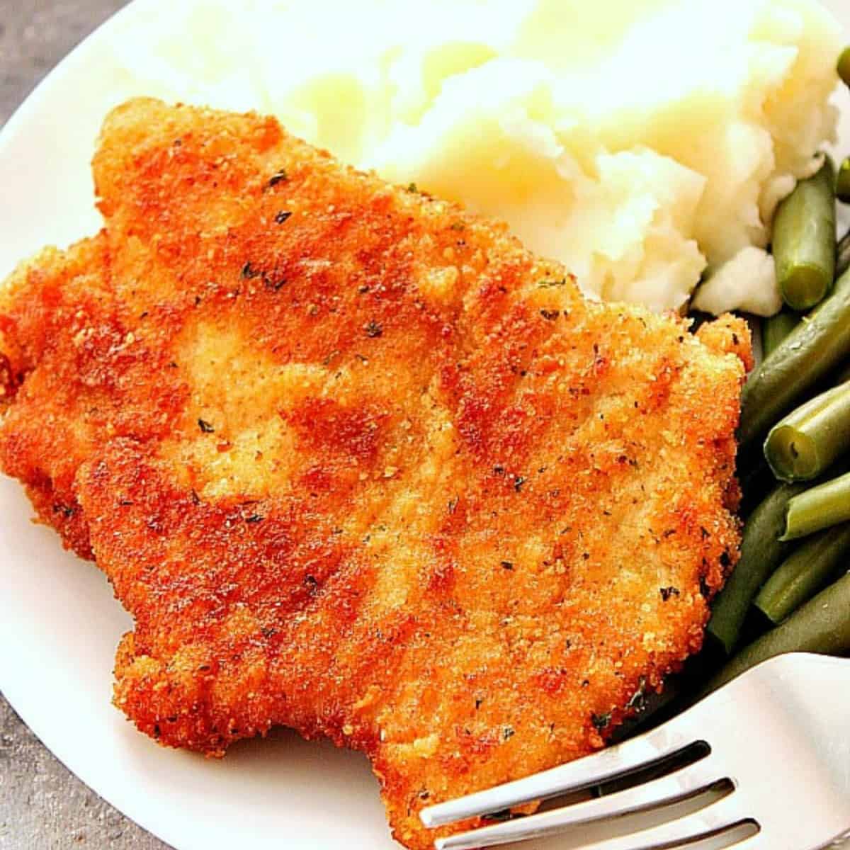 Schnitzel with mashed potatoes on a plate.
