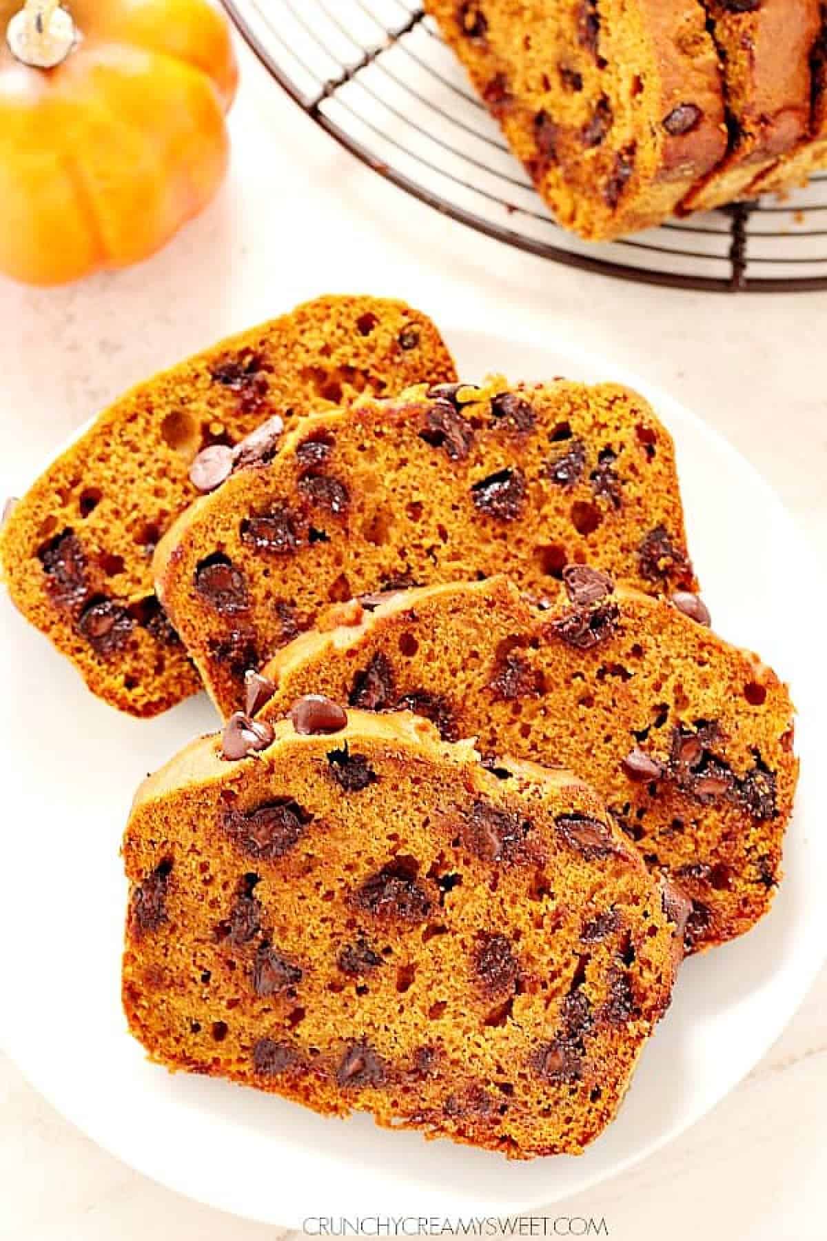Best pumpkin bread recipe Four slices of pumpkin bread with chocolate chips on a plate.