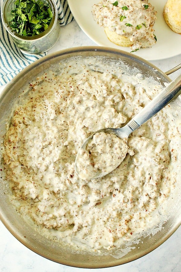 Overhead shot of sausage gravy in stainless steel skillet.