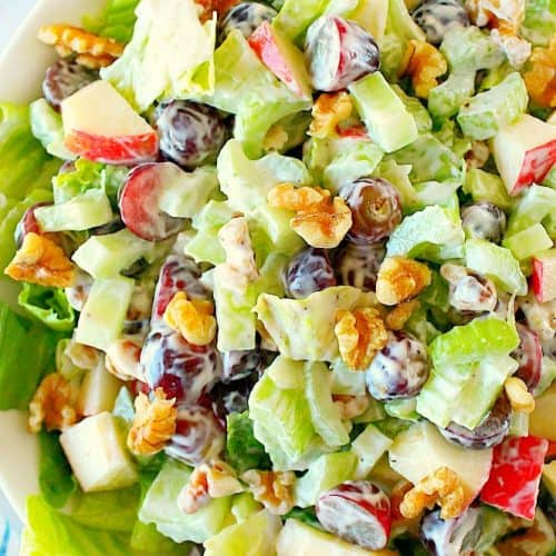 Overhead shot of salad with grapes, apples, celery and lettuce in a bowl.