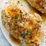 Overhead shot of cooked chicken breast on white plate.