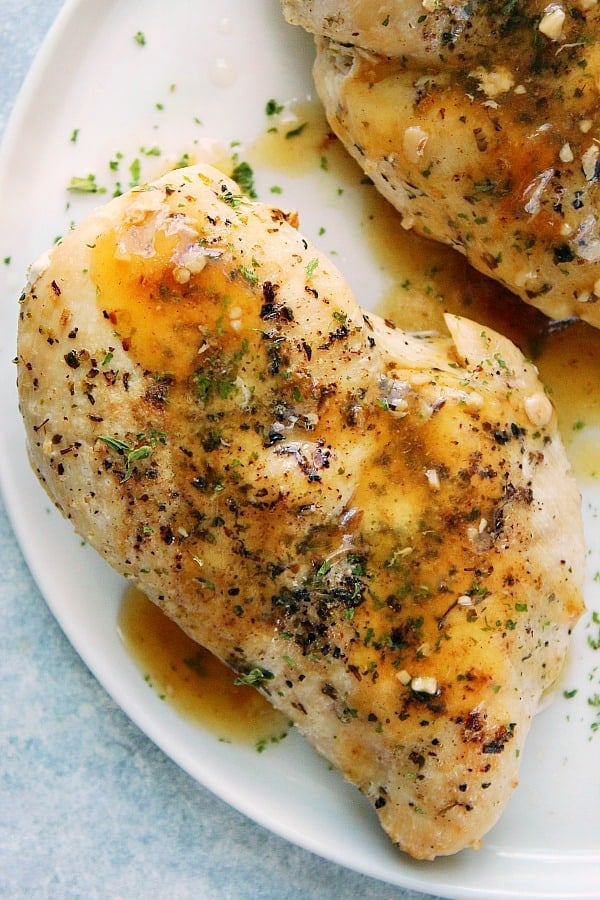 Overhead shot of cooked chicken breast on white plate.