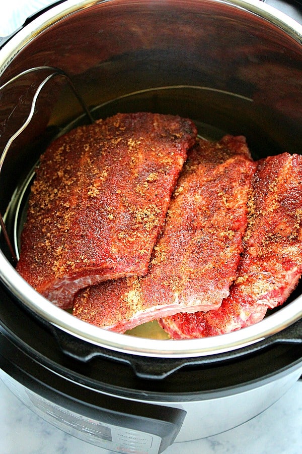 Overhead shot of three pieces of ribs with rub in the Instant Pot.