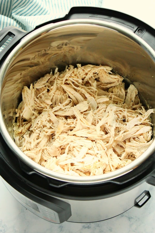 Side shot of shredded chicken in Instant Pot.