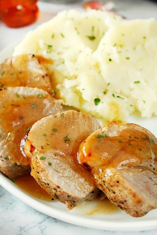 Side shot of slices of pork tenderloin on plate.