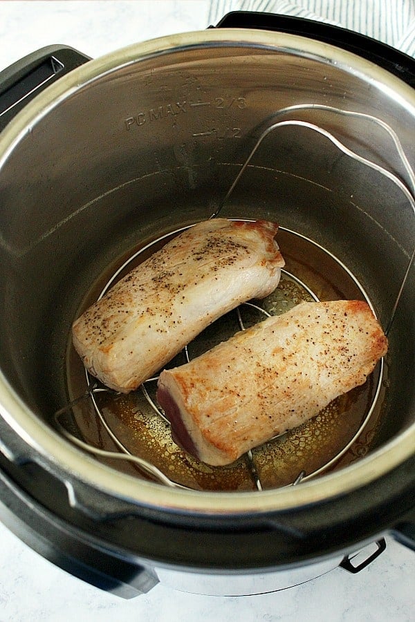Overhead shot of two pieces of pork tenderloin in the Instant Pot, on trivet.