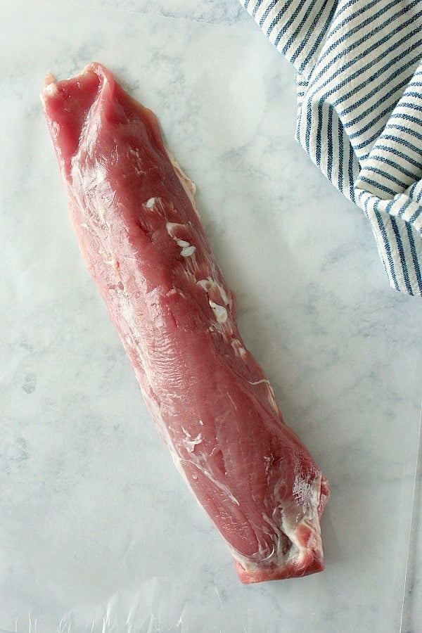 Overhead shot of raw pork tenderloin on marble.