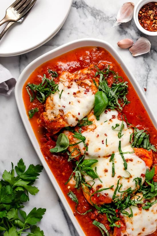 Instant Pot Chicken Parmesan in tomato sauce in white dish.