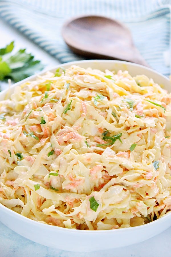 Creamy Coleslaw in white bowl on marble top.